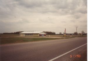 Kiss Carpet's original Mancelona location on US-131 around 1990, a modest building that started a multi-generation family flooring business