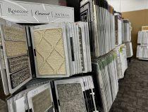 Wide variety of carpet samples on display racks in Northern Michigan Kiss Carpet showroom, including luxurious Rosecore and Crescent brands, to help choose the perfect texture and color.
